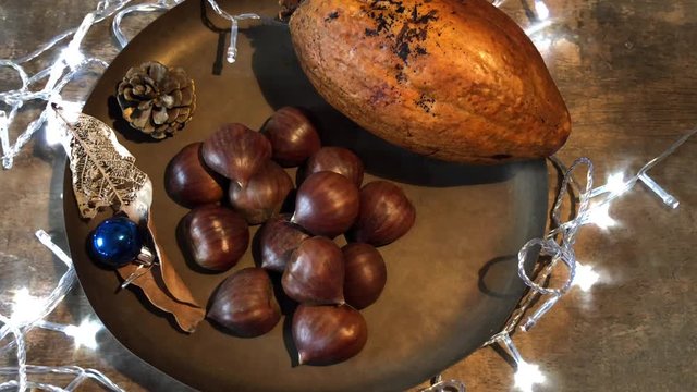 Video with portuguese chestnuts, traditional on christmas table. Flashing lights flashing, white. Christmas Eve, with dried fruits, apricot, chestnut and acerola as an option. Brazilian natal table. O
