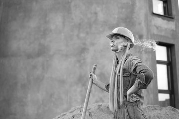 Black-and-white photo of a girl with a cigarette at the construction site