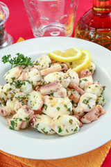 Octopus pieces cooked with garlic and parsley on a plate