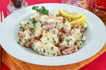 Octopus pieces cooked with garlic and parsley on a plate