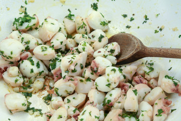 Octopus pieces cooked with garlic and parsley on a plate