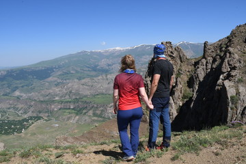 Young couple in the mountains look at the horizon