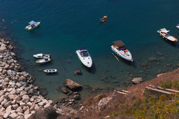 Fototapeta premium Panoramic view of fishing boats and yachts, clear blue sky and the azure sea on the island of Procida, Italy. Near Napoli