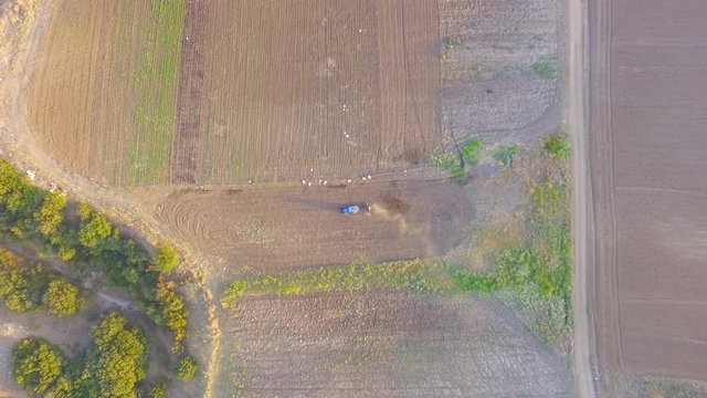 Aerial view of tractor plowing the field. Bird view of tractor plowing the field. Agriculture and countryside lifestyle 