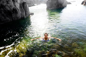 happy woman in holidays swimming in natural pools, Porto Moniz village , Madeira Island