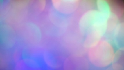 Pastel neon colors defocused lights bokeh. Abstract holographic foil background. Glitter surface
