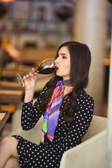Naklejka na ściany i meble beautiful young woman with a glass of red wine in a restaurant
