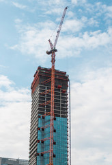 Construction site of building a high-rise building with a cranes against blue sky.