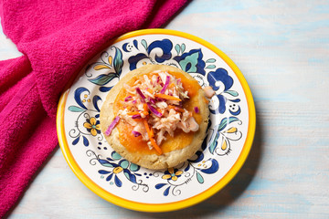 Salvadoran pupusas with coleslaw and tomato sauce on wooden background