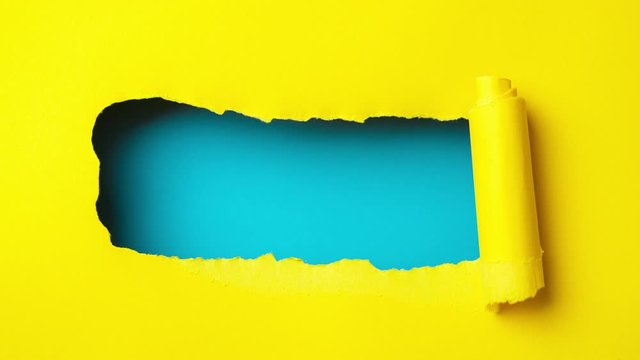 Yellow paper is torn over blue background for message, stop motion, animation.