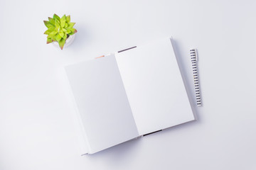 Flat lay mockup with white open notebook on a white background