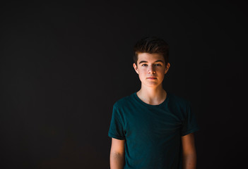 Portrait of a caucasian teenage boy against a dark background.