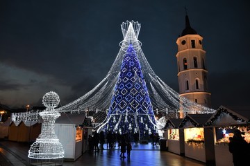 Vilnius, Lithuania - December 9 2019: Beautiful Christmas tree decorated with white and blue lights for Christmas 2019 and New Year 2020, market and celebrations in Vilnius Cathedral square
