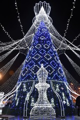 Vilnius, Lithuania - December 9 2019: Beautiful Christmas tree decorated with white and blue lights for Christmas 2019 and New Year 2020, market and celebrations in Vilnius Cathedral square, vertical