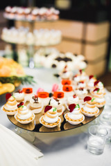 Delicious sweets on wedding candy buffet with desserts, cupcakes