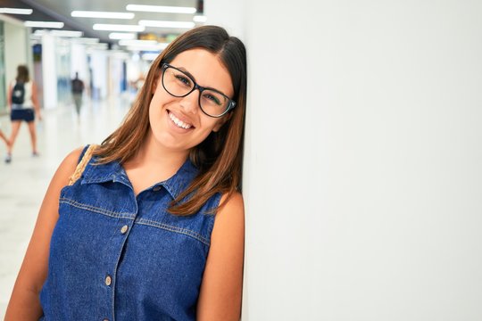 Young traveller woman at the airport going on vacation leaning on the wall