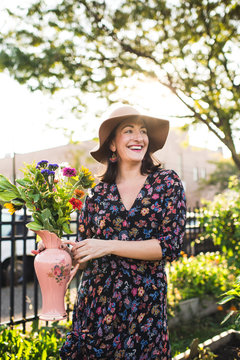 happy woman holding fresh flowers in urban setting