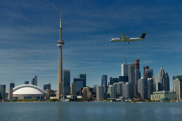Toronto skyline with Rogers Centre CN Tower condo and financial towers and Porter airplane landing...
