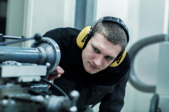 engineer in a workshop looking to machine