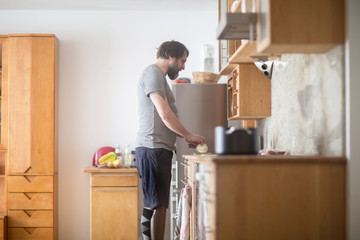 older man with prosthetic leg cooking in a kitchen