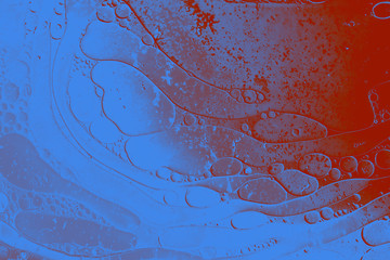 Macro shot of water oil emulsion over colored background