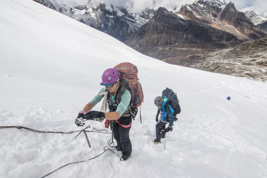Two women mountaineers practice steep snow skills on a glacier