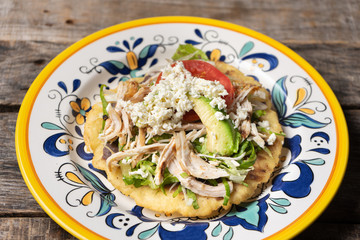 Yucatecan salbutes with chicken meat on wooden background