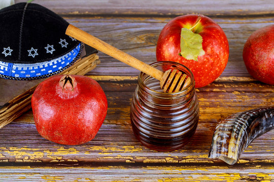Honey on the pomegranate and apples. Jewish new year Rosh Ha Shana kippah yamolka and shofar