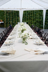 Table setting with sparkling wineglasses and cutlery in tent outdoors, copy space. Place setting at...