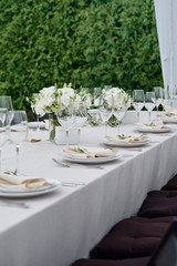 Table setting with sparkling wineglasses and cutlery in tent outdoors, copy space. Place setting at wedding reception. Table served for wedding banquet in restaurant
