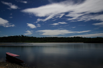 A boat on the Napo River illuminated by moonlight in a long exposure shot. Ecuador