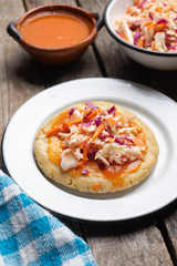 Salvadoran pupusas with coleslaw and tomato sauce on wooden background