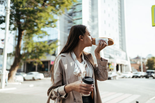 Business Lady Snacking On A Sandwich And Coffee On A City Street