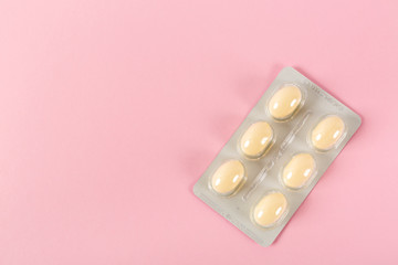 Tablets in strip over pink background, vaginal antibacterial capsules