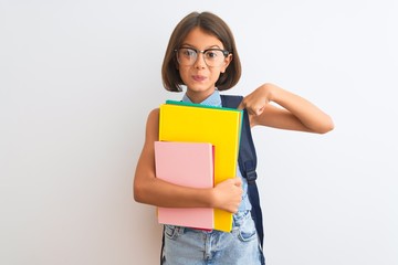 Beautiful student child girl wearing backpack glasses books over isolated white background with surprise face pointing finger to himself