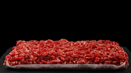 Chopped raw meat  on a black  background.