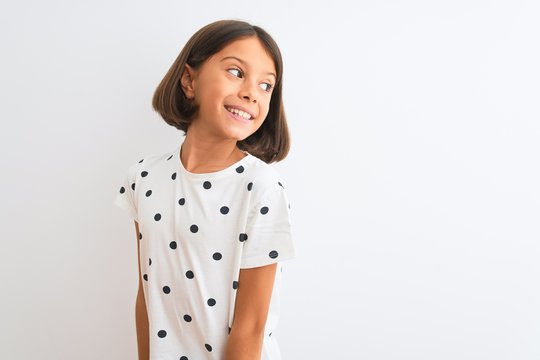 Young Beautiful Child Girl Wearing Casual T-shirt Standing Over Isolated White Background Looking Away To Side With Smile On Face, Natural Expression. Laughing Confident.