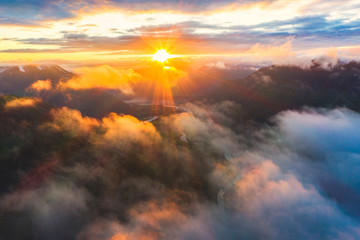 Aerial view of sun rays at sunset lighting up the clouds over Romsdalen valley, Andalsnes, More og Romsdal county