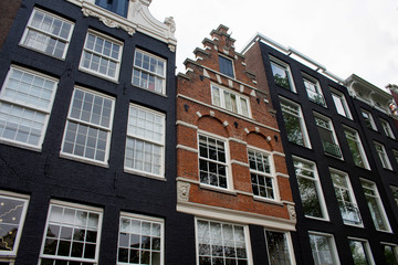 Bottom view of historical, traditional and typical building showing Dutch architectural style in Amsterdam. It is a sunny summer day.