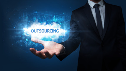 Hand of Businessman holding OUTSOURCING inscription, successful business concept