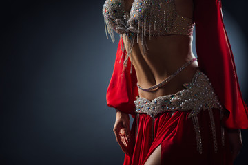 Beautiful belly dance of a girl in a red decorated ethnic dress in dark