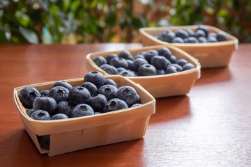 Blueberries lie on the table in portion boxes of birch bark. Delicious and healthy food contains a...
