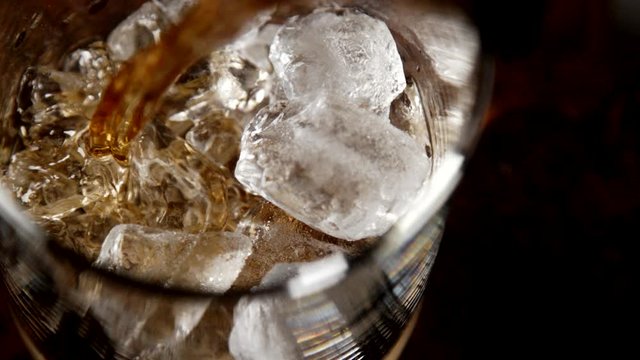 Whiskey or Scotch Pour Over Ice in Slow Motion 