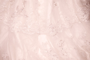 Cream, powdery, pale pink lace fabric with sequins. Delicate wedding background. Openwork