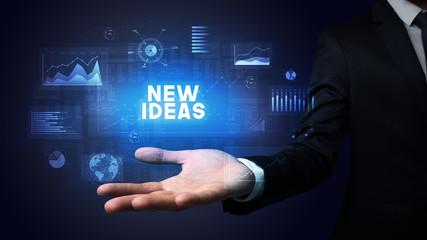 Hand of Businessman holding NEW IDEAS inscription, business success concept