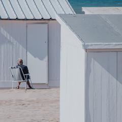 dame assise au milieu des cabanes de plage