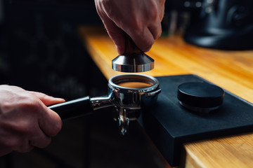 tempered coffee in portafilter on a dark background
