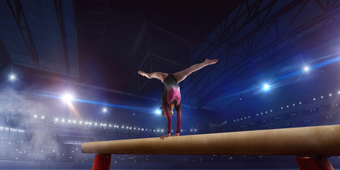 Female gymnast on professional arena.