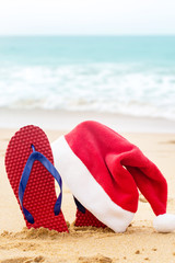 Santa hat and shoes by the turquoise ocean
