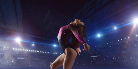 Female gymnast on professional arena.